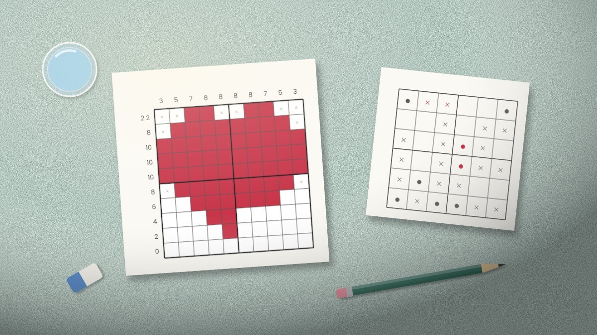 Colorful logic puzzle booklet open on a desk with a nonogram grid and pencil